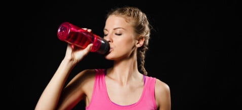 femme boit de l'eau dans une gourde